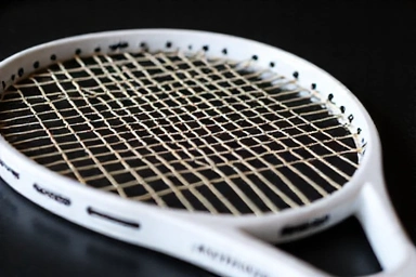 Close-up of tennis racket strings being tensioned