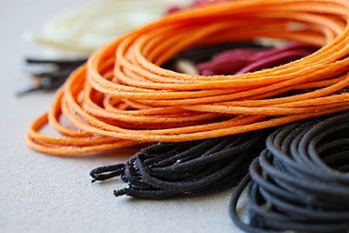 Various tennis strings in different colors and materials, coiled and displayed